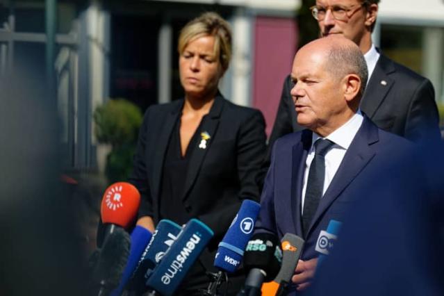 What are the risks of Scholz's position regarding German aid to Ukraine?